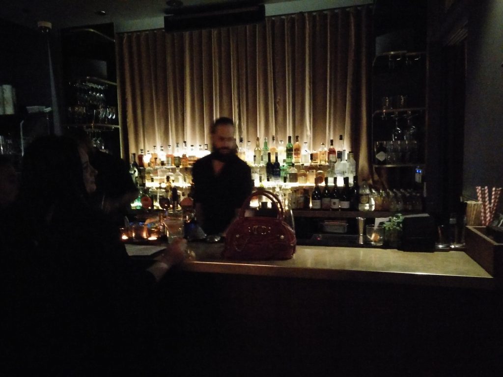 Interior (night) - FADE IN: A very mysterious red Lynchian handbag on the counter in front of a blurry bartender. (photo: Patrick von Sychowski - Celluloid Junkie)