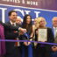 Tara Tomcsik-Husak (President and CEO of Troy Chamber of Commerce) holds a Proclamation on behalf of the City of Troy as Paul Glantz (President and Co-Founder of Emagine Entertainment), Ethan Baker (Mayor of the City of Troy), and Suzy Siegle (Walsh College President and CEO) cut the ceremonial ribbon.