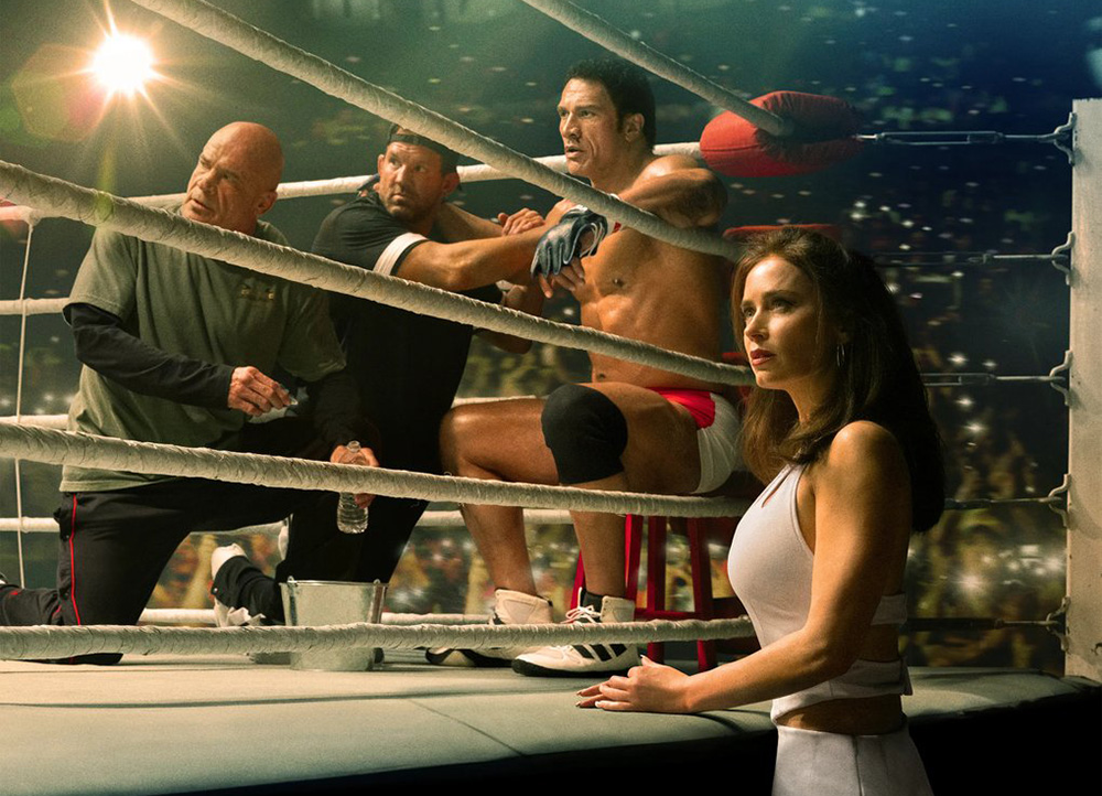 Dwayne Johnson (seated in the boxing ring) and Emily Blunt in "The Smashing Machine" a biopic of UFC competitor Mark Kerr