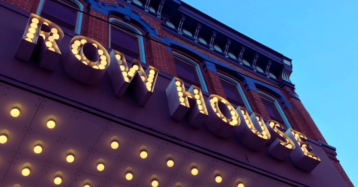 Row House Cinema’s name in lights is set in front of a blue sky