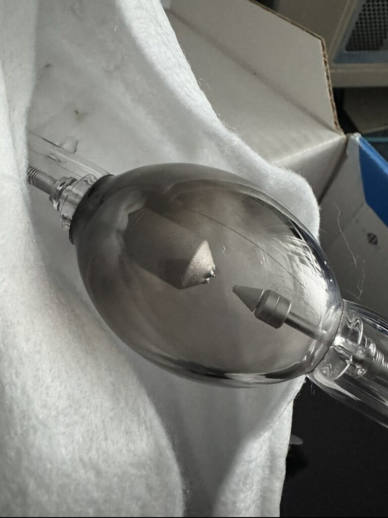 A heavily used xenon projection bulb resting on a white cloth.