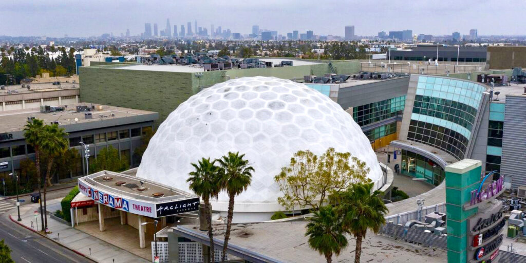 The Cinerama Dome sits in front of the former 14-Screen ArcLight Hollywood cinema on Sunset Boulevard in Hollywood, California. Seen here with downtown Los Angeles in the background.