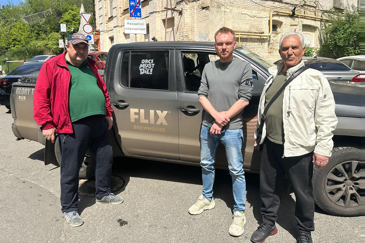 Two members of the Giraffe Mall ownership group Andriy Diubenko (left) and Volodymyr Rozvalov with a member of the Ukrainian military (center) after randomly spotting Flixmobile #2 on the streets of Kyiv.