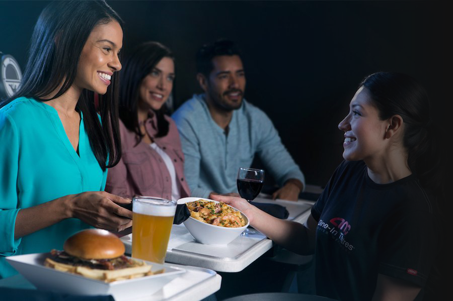 Guests enjoying food and drinks during a dine-in cinema service